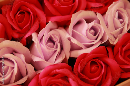 Red and pink roses background. Artificial flowers. 