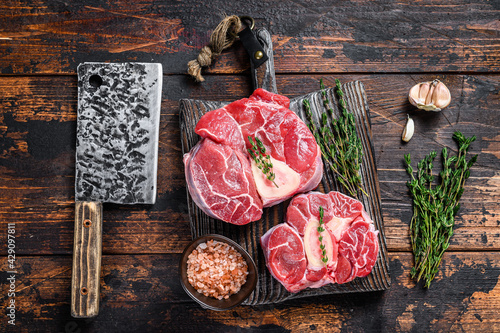 Raw veal shank steak meat osso buco, cooking italian ossobuco. Dark Wooden background. Top view