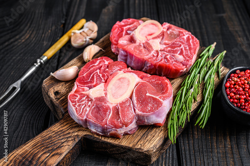 Raw meat osso buco veal shank steak , making italian ossobuco. Black Wooden background. Top view photo