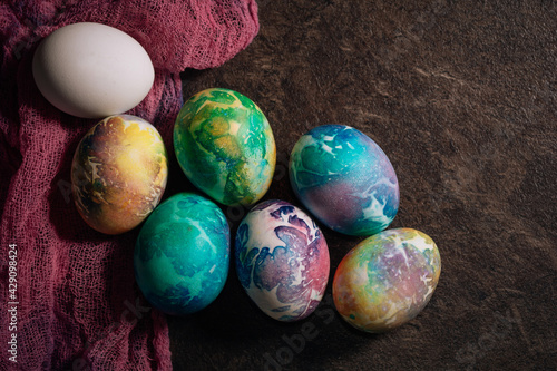 multi-colored Easter eggs of blue tones on a pink cloth background. Easter eggs in low key