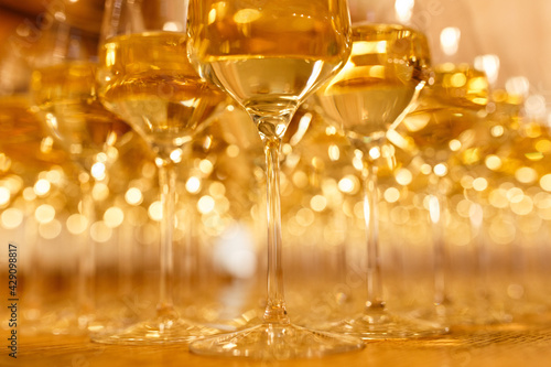 A lot of glasses with champagne or white wine at a party.