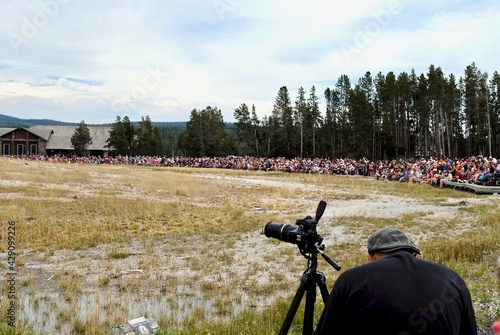 Yellowstone National Park, Wyoming, USA: Crowds of tourists gather to watch Old Faithful Geyser. It is a highly predictable geothermal feature that makes it a popular tourist attraction.