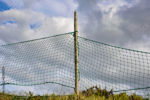 A net fence on the grass with the sky behind