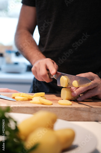 Koch schneidet Kartoffel mit einem Messer