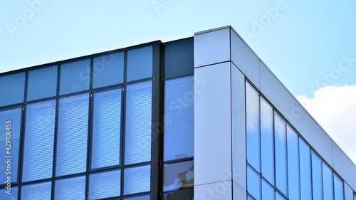 The glazed facade of an office building with reflected sky. Modern architecture buildings exterior background. Clouds sky reflection.