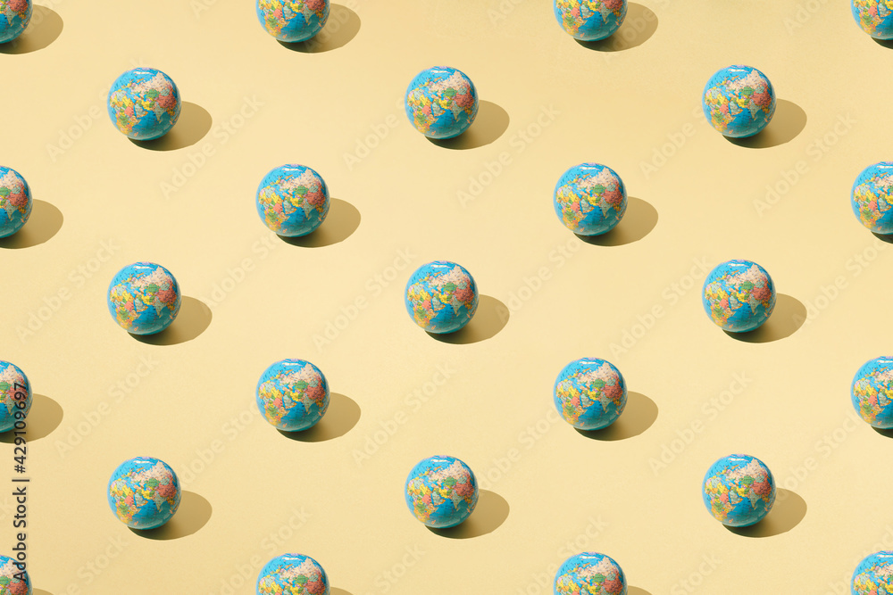 Arranged globe on yellow cream pastel color. Minimal pattern. Arranged globe on yellow cream pastel color. Minimal pattern.