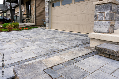 Luxury hardscape driveway shows pavers with pattern and  and matching landing and step. photo