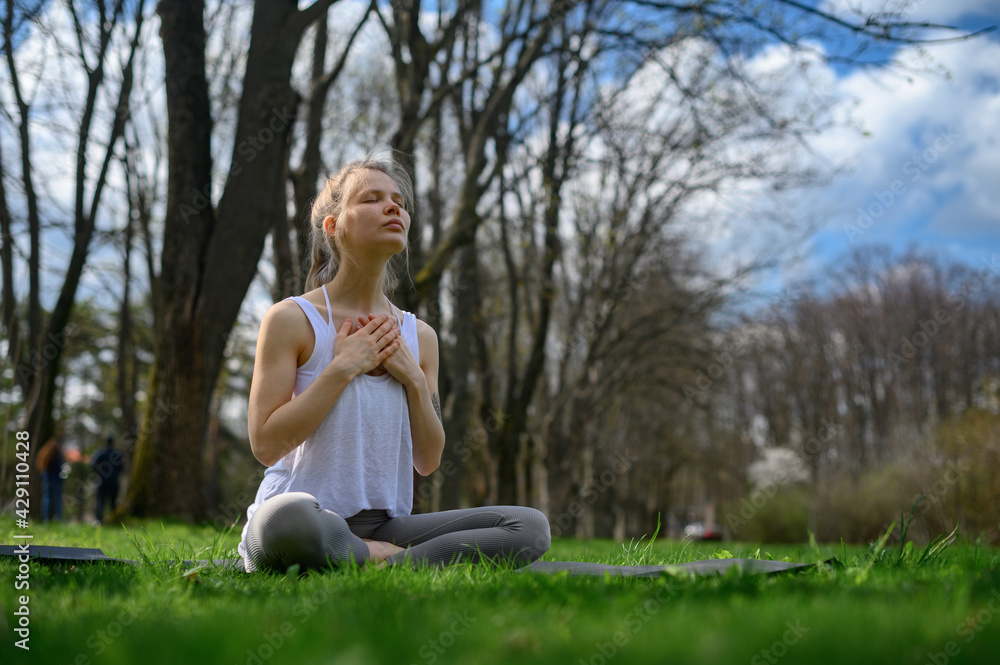 Yoga practice and meditation outdoor. Girl in the park