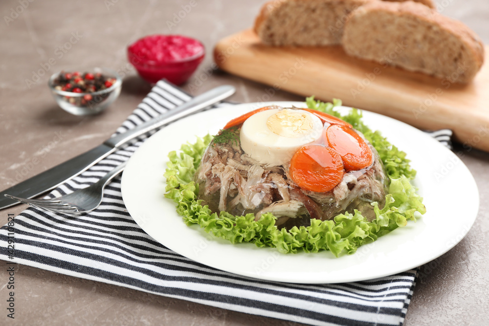 Delicious aspic with meat and vegetables served on grey table