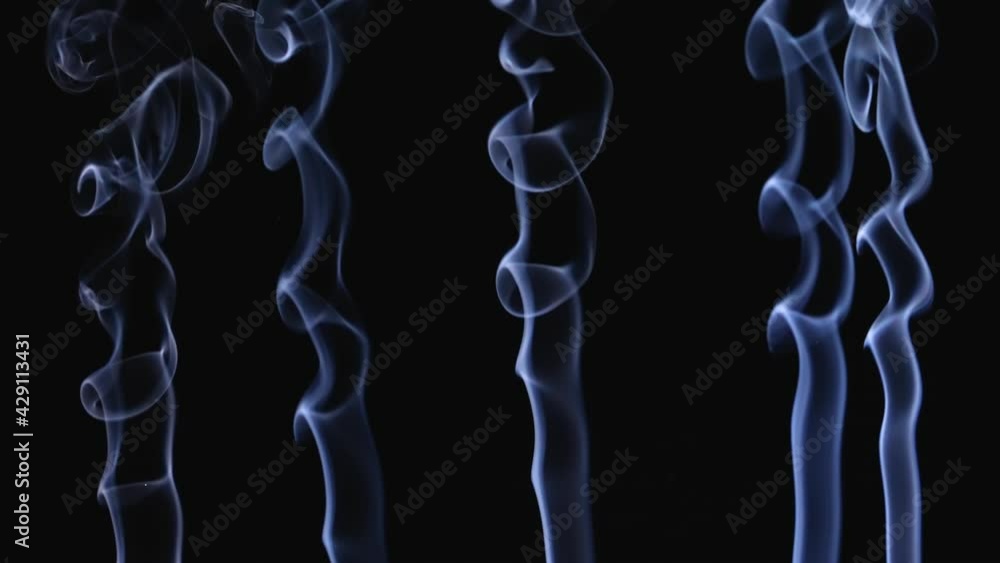 White smoke floating in space on a black background in slow motion. Smoke jets form intricate abstract patterns. Close up. White smoke floating in space on a black background in slow motion. Smoke jets form intricate abstract patterns. Close up.