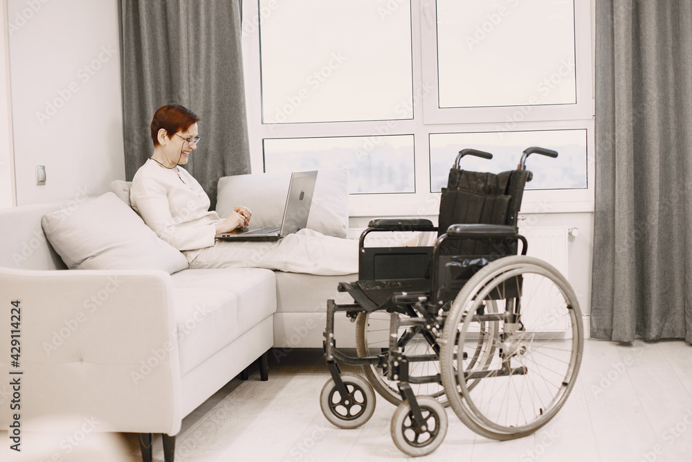 Handicapped woman with lapot lay on couch Handicapped woman with lapot lay on couch