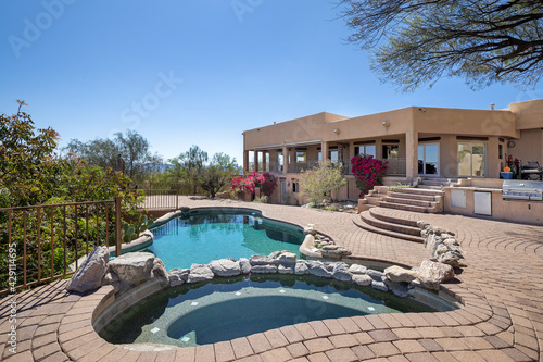 Swimming pool with hot tub and terraced patio at a luxury home in a desert environment. © pics721