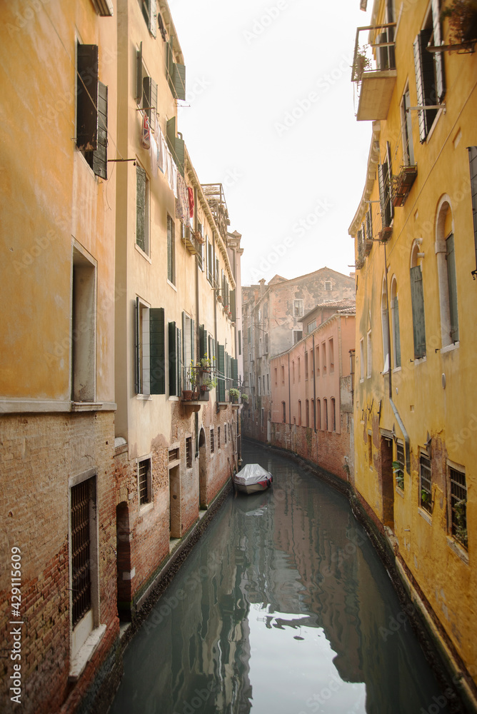 Bote solitario aparcado en un canal de venecia debajo de las ventanas de las viviendas