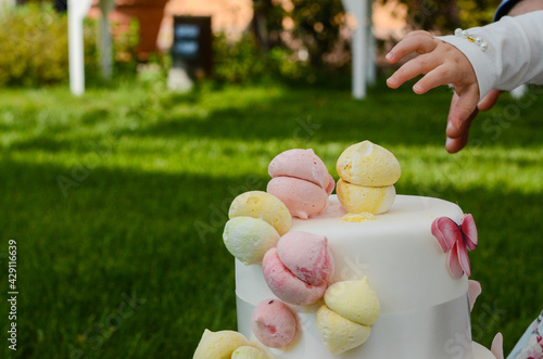 Little girl picking a meringue from her birthday cake photo