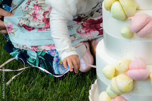 Little girl sitting in front of her birthday cake photo