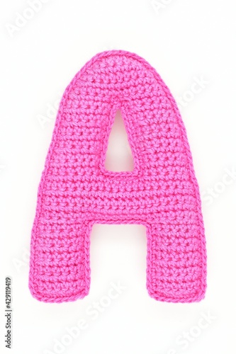 Knitted letter A, pink color, on a white background. ABC, font, alphabet, texture, textile, printing, amigurumi, handmade.