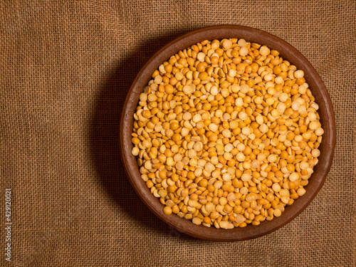 yellow split peas in a wooden bowl isolated photo