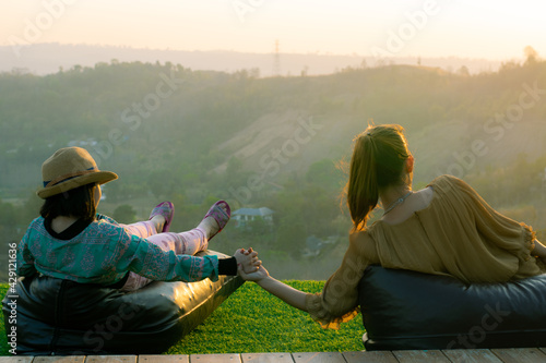 two people on a bench mountain view sunset