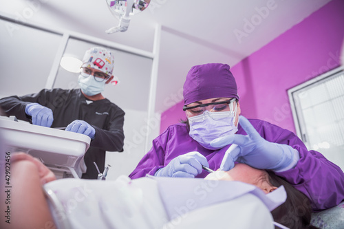 Mexican dentist and assistant with female patient