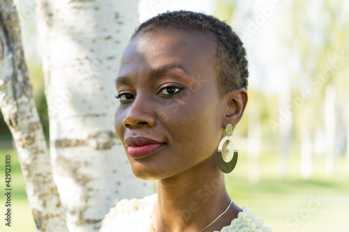 Foto Portrait of an African-American woman standing in a park, straight to the camera