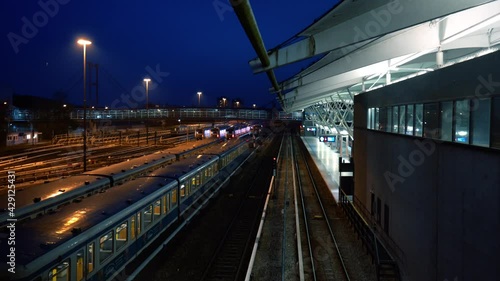 Subway stops at the overground station in the evening. The station is illuminated at night. Scene at the station Munich 