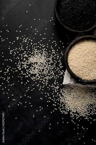 Black and white sesame seed on black background. Organic food concept