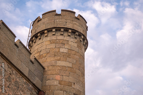 The walls and towers of the old palace on the background of a cloudy sky