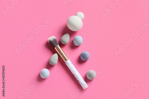 Makeup sponges and brush on color background