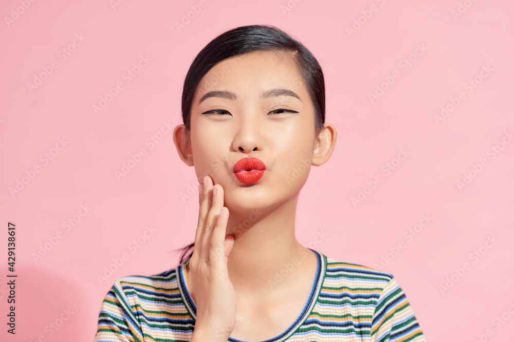 Half-length portrait of sexy smiling dark -haired young woman sending us a blowing kiss Half-length portrait of sexy smiling dark -haired young woman sending us a blowing kiss