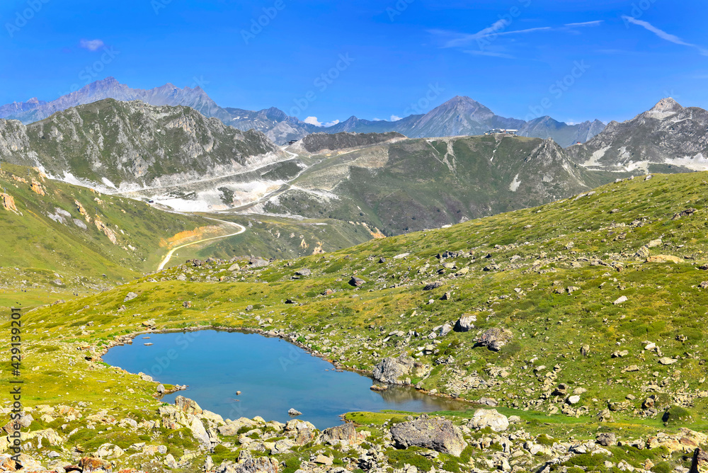 alpine mountain landscape  with a little lake in rocky meadow