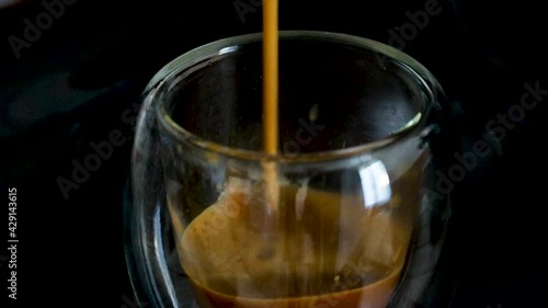 café expresso remplissant dans un verre transparent photo