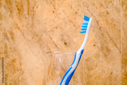 Toothbrush stands in a glass on a beige background 