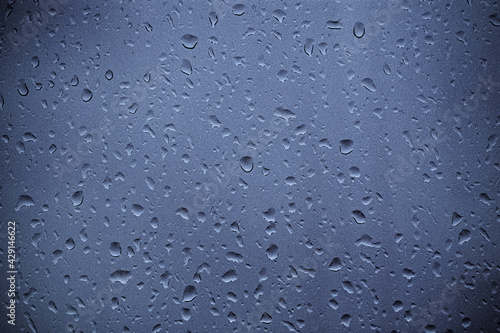 Water drops on the colored window glass. Abstract: water and glass. Concept: humidity.