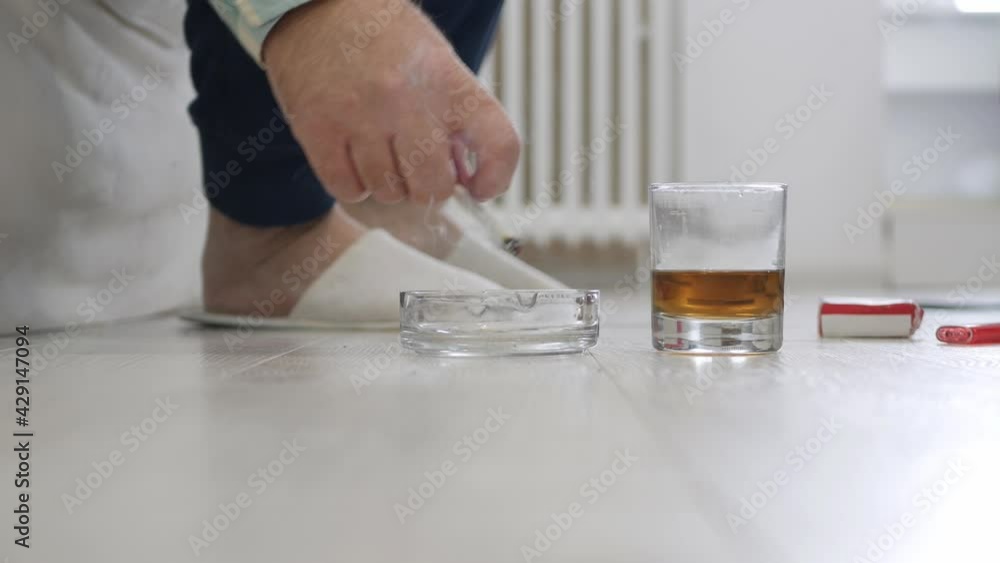 Adult Person Wearing Slippers Drink Alcohol, Smoke a Cigarette and Gets in the Bed. Adult Person Wearing Slippers Drink Alcohol, Smoke a Cigarette and Gets in the Bed.