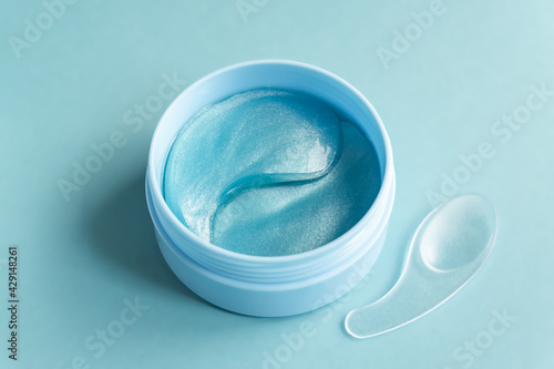 open jar with collagen anti-ageing patches for the eyes and face. Close up, top view.