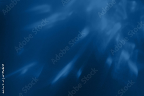 Trendy blue colored low contrast abstract background with light and shadows caustic effect. Light passes through a glass. Water background.  photo