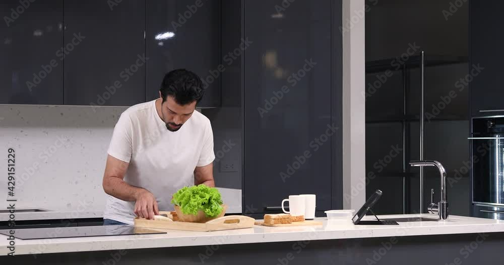 Hispanic man search and using culinary application on digital tablet for cooking at home Hispanic man search and using culinary application on digital tablet for cooking at home