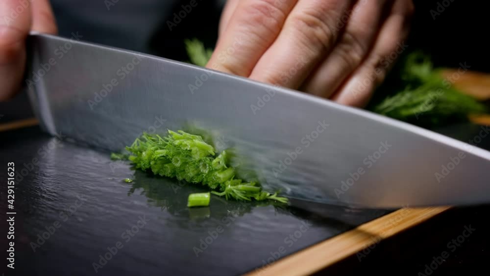 Female hands chopping dill with kitchen knife. Macro shot, 150 fps, slow motion Female hands chopping dill with kitchen knife. Macro shot, 150 fps, slow motion