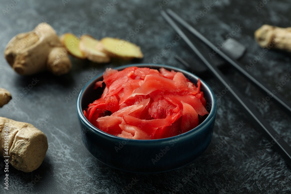 Bowl with red pickled ginger and chopsticks on black smokey background Bowl with red pickled ginger and chopsticks on black smokey background
