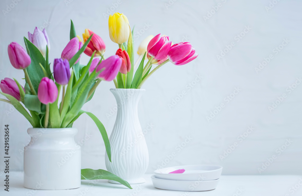 Home decoration with spring tulips bouquets in white vases Home decoration with spring tulips bouquets in white vases