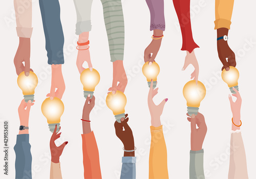 Brainstorming concept.Metaphor of diverse people proposing or sharing innovative ideas solutions and agreements.Collaborating colleagues or co-workers.Hands holding a light bulb.Teamwork