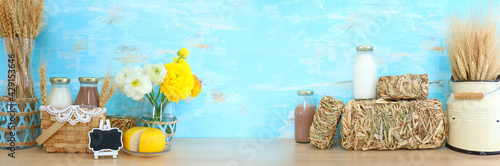 image of dairy products, crops and hay piles over wooden background. Symbols of jewish holiday - Shavuot photo