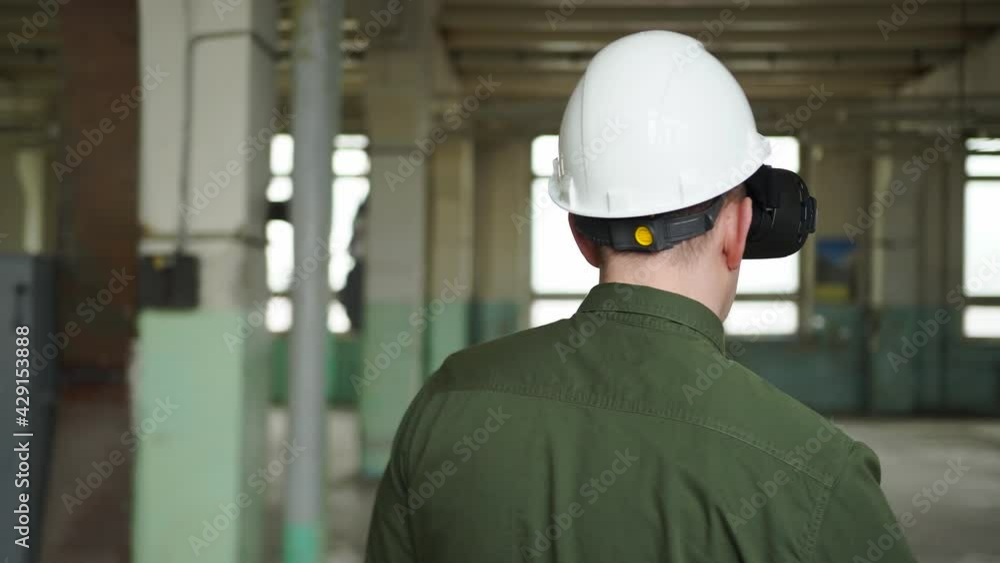 Designer architect builder wearing protective helmet virtual reality glasses walks through construction site. Moves digital virtual objects hands looks characteristics broadcast glasses. VR technology Designer architect builder wearing protective helmet virtual reality glasses walks through construction site. Moves digital virtual objects hands looks characteristics broadcast glasses. VR technology
