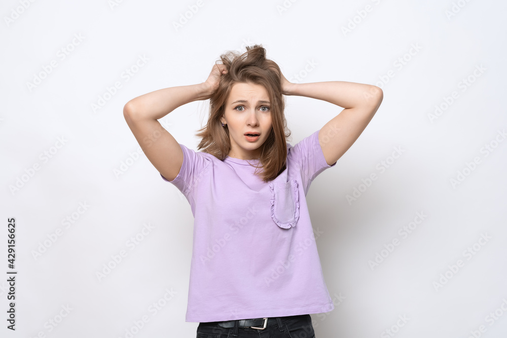 Portrait of worried and anxious girl, grab head and panicking, staring alarmed, dont know what do Portrait of worried and anxious girl, grab head and panicking, staring alarmed, dont know what do