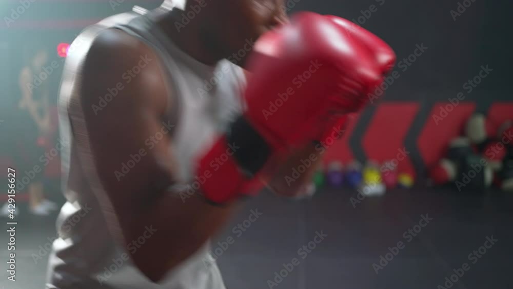 Africa American or athletic man wearing boxing glove doing boxing with trainer in the fitness gym. Feeling tired and exhaust after exercise. Lift his arms to wipe away sweat. Workout lifestyle concept Africa American or athletic man wearing boxing glove doing boxing with trainer in the fitness gym. Feeling tired and exhaust after exercise. Lift his arms to wipe away sweat. Workout lifestyle concept