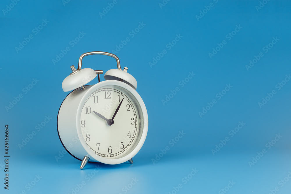 White alarm clock on blue background. White alarm clock on blue background.