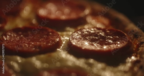 Pepperoni pizza is cooking in the oven, close up shot. Baking Italian pizza with tomato sauce and mozzarella cheese boiling in an oven - 4k footage