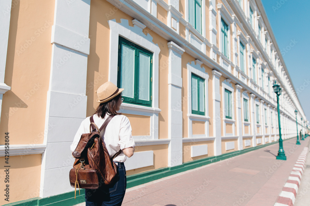 Behind of young asian woman with backpack and straw hat travel in old town Bangkok, Thailand Behind of young asian woman with backpack and straw hat travel in old town Bangkok, Thailand
