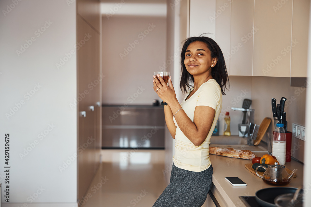 Attractive young woman drinking tea at home Attractive young woman drinking tea at home