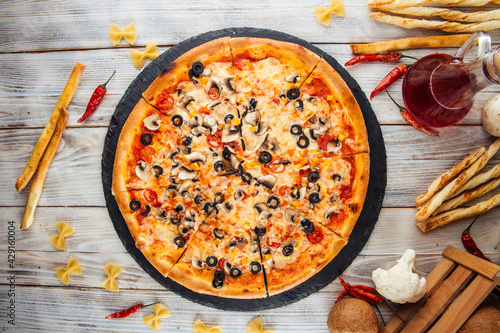 Top view on fresh baked capricciosa pizza with olives
